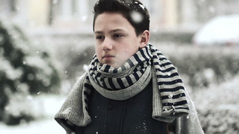 Young sad boy in snowy weather
