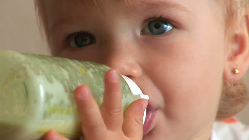 Child drinks milk from a bottle
