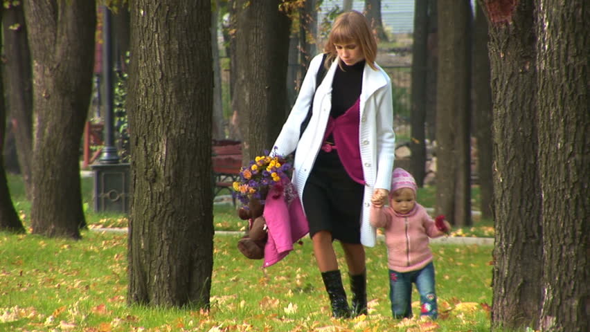Mother and child on a walk in the park in autumn