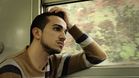 Traveling by train. Man traveling by train, looking through the dirty window