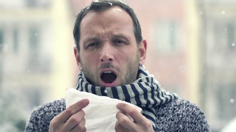 Sick man blowing nose in snowy weather, super slow motion, shot at 240fps
