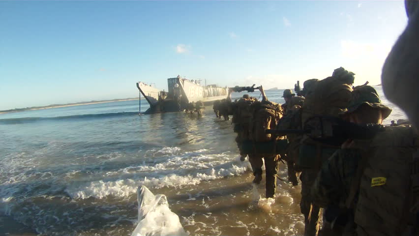 Marine troops loading on amphibious assault boat for combat action. American troops preparing to leave combat field on boat. 