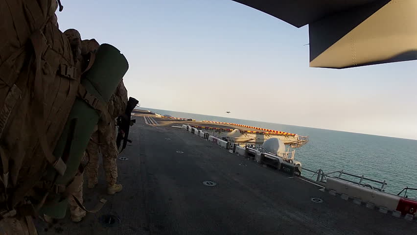 Morning sun off of battle ship. Silhouette of military aircraft on Navy aircraft carrier perorating for combat. 