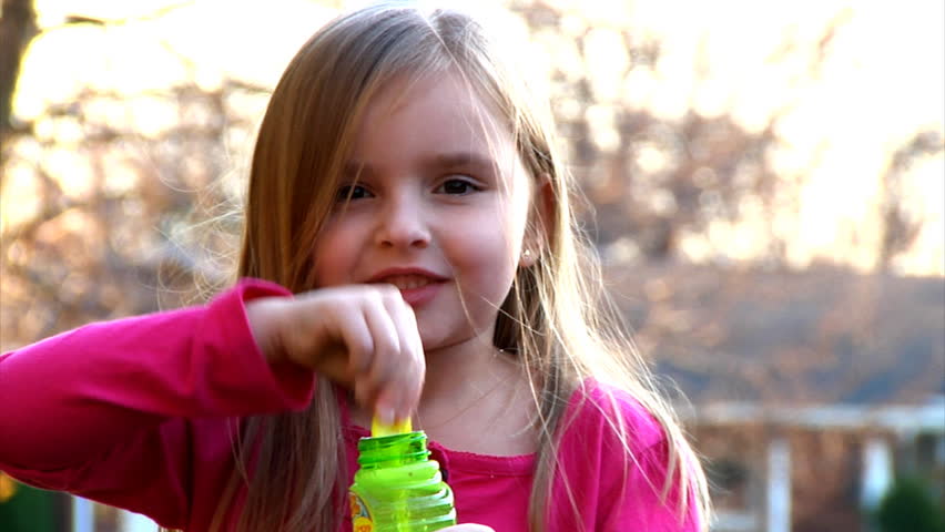 A little girl blows bubbles.  Shot at 60fps.