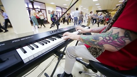 MOSCOW, RUSSIA - OCT 27, 2012: Pairs dance and musician plays synths in foyer before World championship on Acrobatic Rock-n-roll, World Masters boogie-woogie at Universal sports complex RGUFKSMiT.