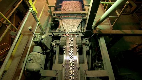 Extra wide shot of conveyor belt depositing cobalt ingots