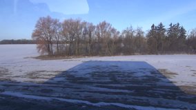 passenger bus shadow on winter field snow near highway