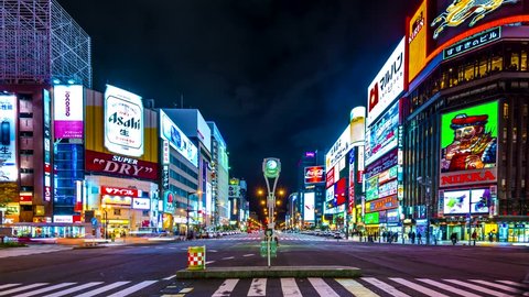 SAPPORO, JAPAN - OCTOBER 23, 2013: Pedestrians and traffic pass through Susukino district at night. Susukino is designated one of the three major red-light districts of Japan.