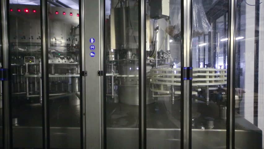 Equipment for bottling of beer behind safety guards with doors in the brewery shop