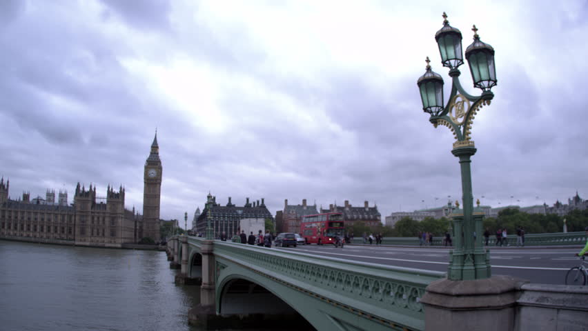 Pan across unidentified people on Westminster bridge to Westminster palace,