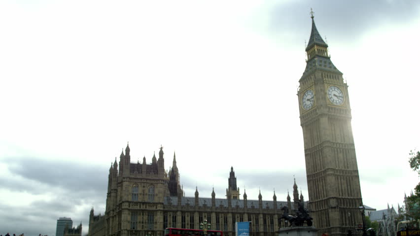 Zoom out view of Westminster palace against cloudy sky in London, England