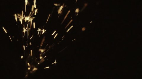 sparks frying on the black background during metal grinding