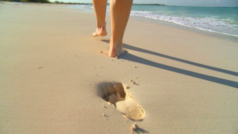 Young caucasian girl leaving footprints in the white sand of a tropical beach 60 FPS