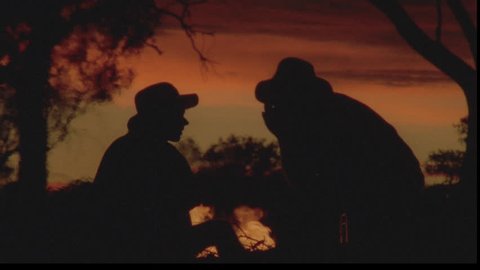 silhouette of two men in front of fire