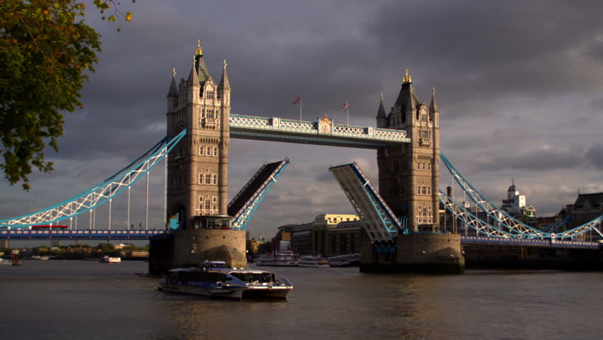 LONDON, UK - OCTOBER 11, 2011: Dark clouds behind Tower bridge, boat gliding on