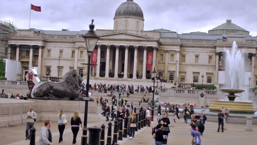 LONDON, UK - OCTOBER 11, 2011: people walk around and Red bus passes Trafalgar