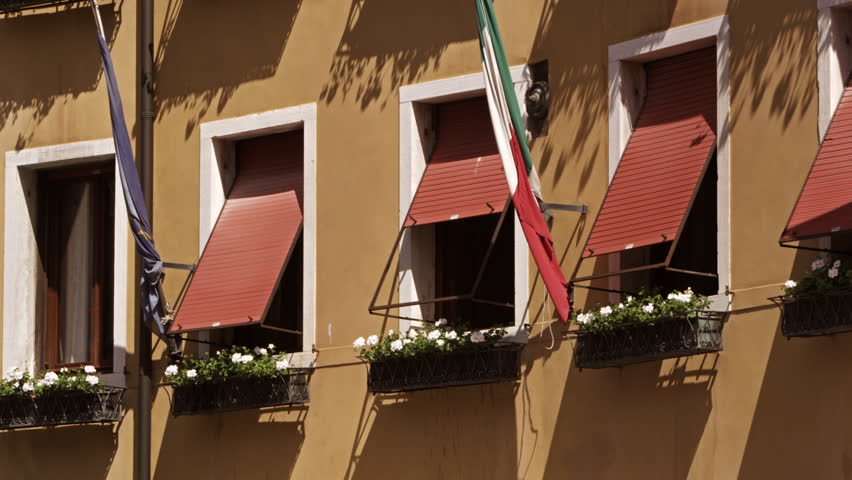 Windows and flags on side of building, slow motion, Venice