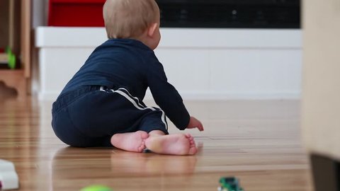 A mother playing toy cars with her toddler boy