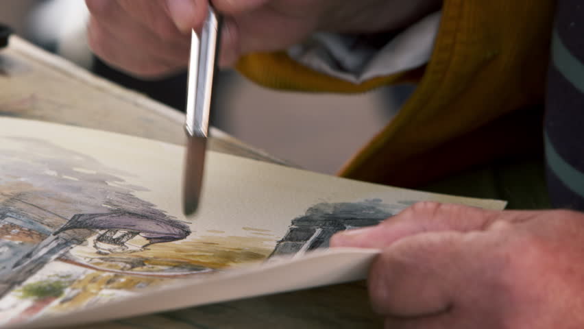 Close up shot of artist painting using watercolors a scene in Venice