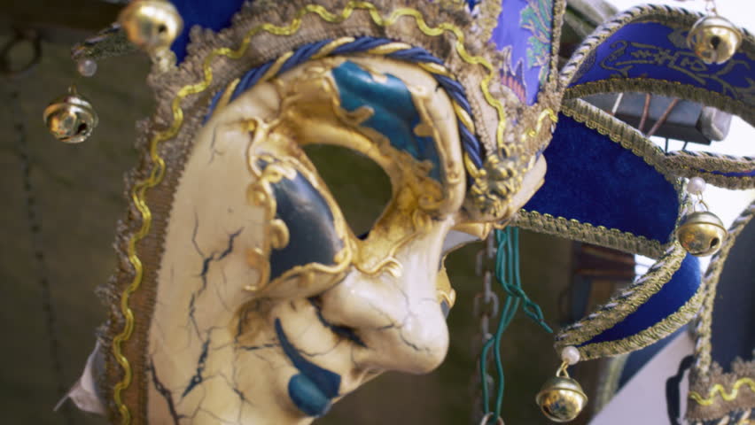Close up tilting down shot of several elegant carnival masks