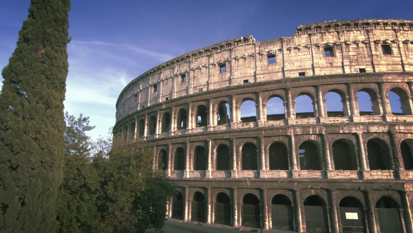 Slow motion, angled pan shot of Colosseum to street