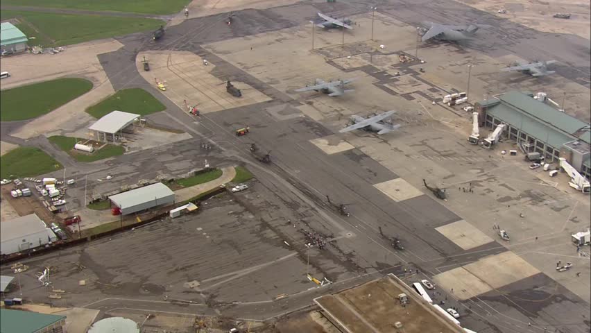 Flood Rescue City Helicopter Airport. Hurricane victims walking down runway with personal belongings.