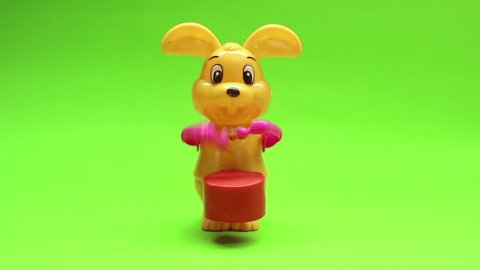 Yellow rabbit doll beats drum on green screen