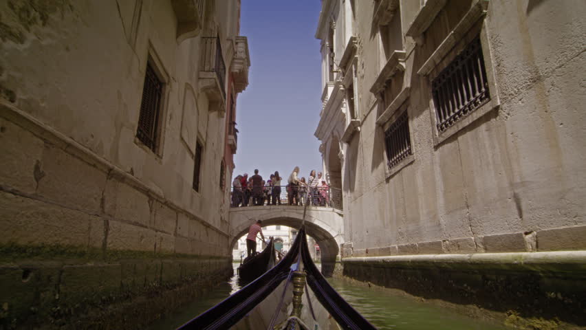 VENICE, ITALY - MAY 2, 2012: Gondola glides toward bridge near the Grand Canal
