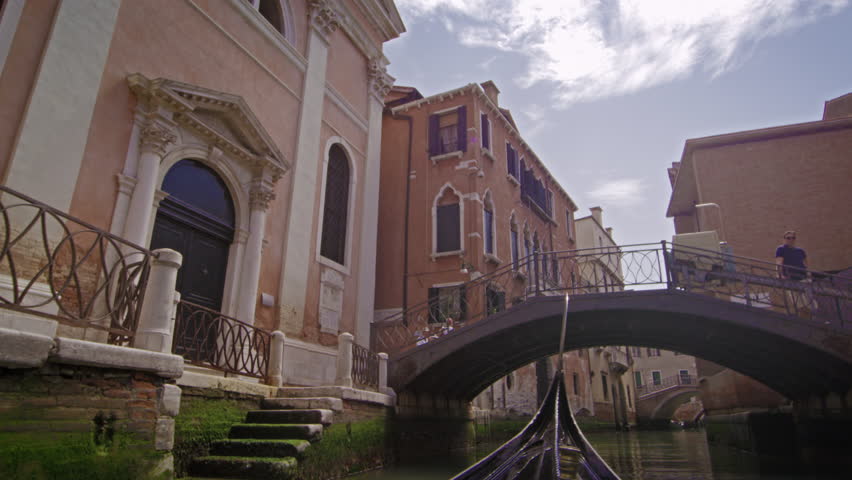 VENICE, ITALY - MAY 2, 2012: Slow motion shot of gondola under bridge