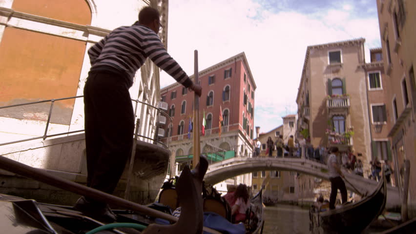 VENICE, ITALY - MAY 2, 2012: Slow motion shot of two gondolas by bridge