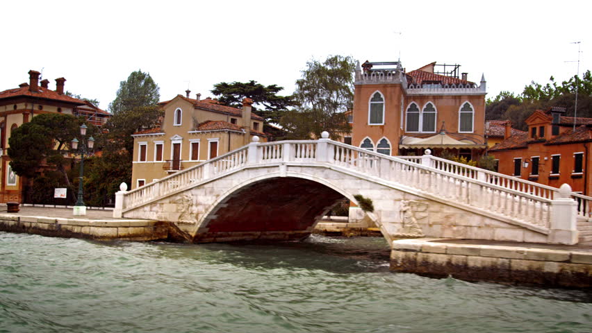 VENICE, ITALY - MAY 2, 2012: Tracking shot of bridge, boat, and buildings along