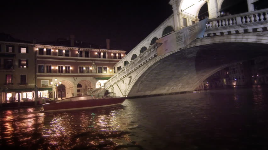 VENICE, ITALY - MAY 2, 2012: A single motor boat travels underneath the Rialto