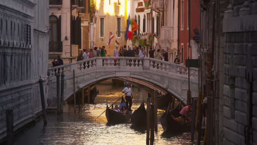 VENICE, ITALY - MAY 3, 2012: Slow motion shot of people crossing a bridge over a