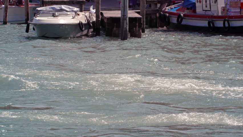 VENICE, ITALY - MAY 4, 2012: Slow motion shot of man driving black boat in