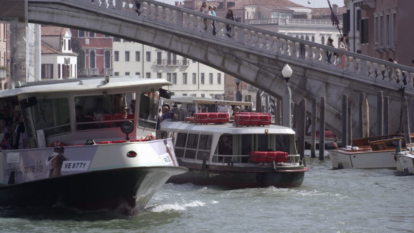 VENICE, ITALY - MAY 4, 2012: Slow motion shot of tourist ferries crossing under