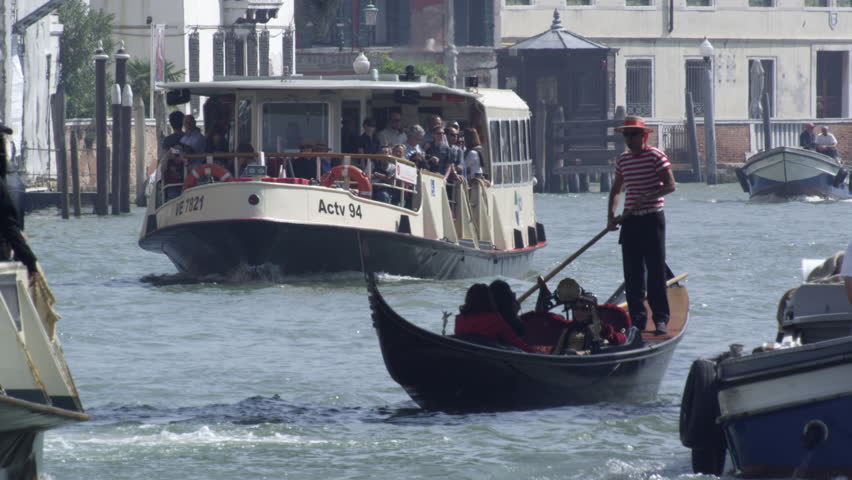 VENICE, ITALY - MAY 4, 2012: Slow motion shot of a gondolier navigating the busy