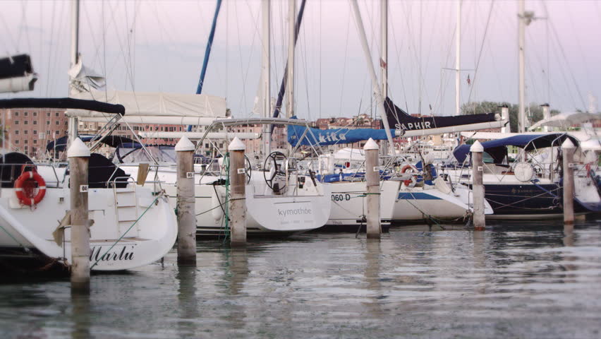VENICE, ITALY - MAY 3, 2012: Static shot of the stern of some sailboats docked