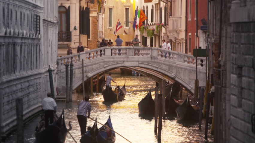 VENICE, ITALY - MAY 3, 2012: Slow motion shot of gondolas traveling down a canal