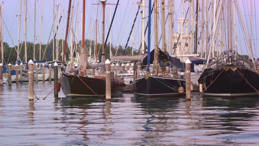 VENICE, ITALY - MAY 3, 2012: Panning shot of sailboats docked in the marina.