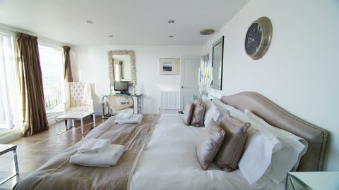 Interior view of elegant bedroom in a stylish beachside home with lots of natural light. No people.