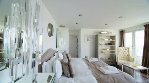 Interior view of elegant bedroom in a stylish beachside home with lots of natural light. No people.