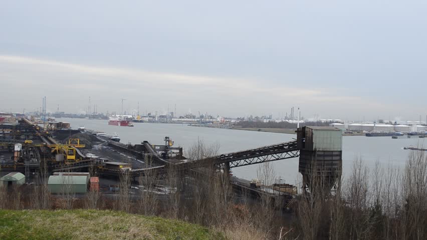 View over docks and traffic within port of Antwerp when big cargo ship is passing by