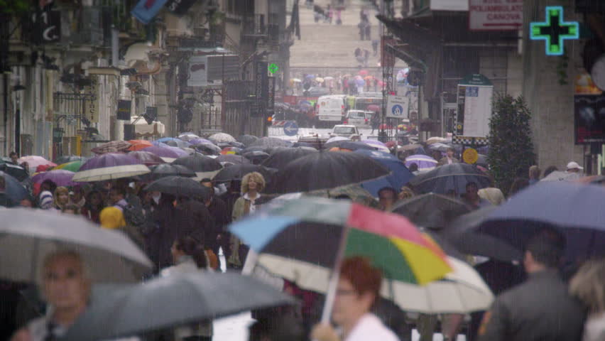 ROME, ITALY - MAY 7, 2012: Overly crowded street in Rome, filled with umbrellas.