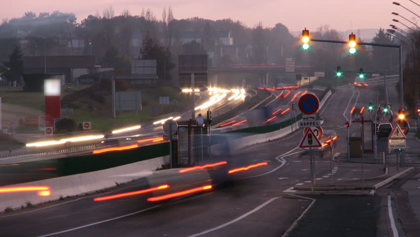 Headlights at sunset on highway, HD time lapse clip.