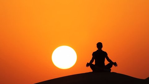 silhouette of woman doing yoga at sunset