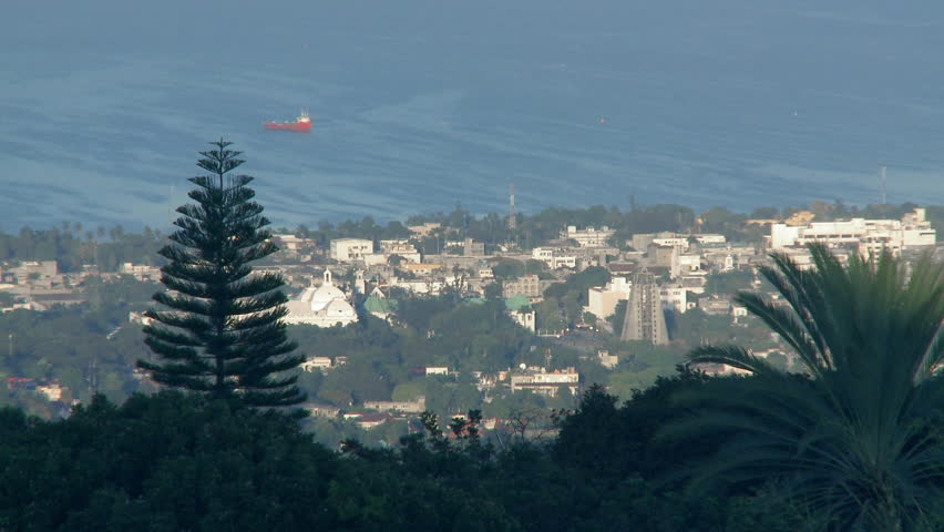 Port-au-Prince, Haiti - Jan 2009:  View of a cargo ship off the coast of the capital city of Port-au-Prince, Haiti, with cathedrals visible in the foreground.
