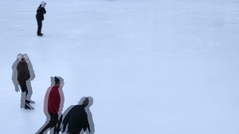 People ice skating in city, video
