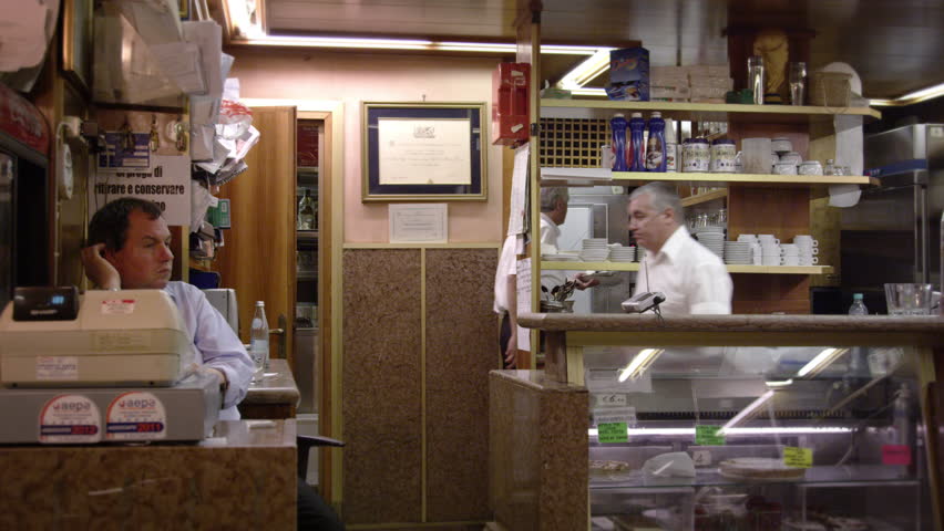 Static slow shot of three men working in an Italian cafe.