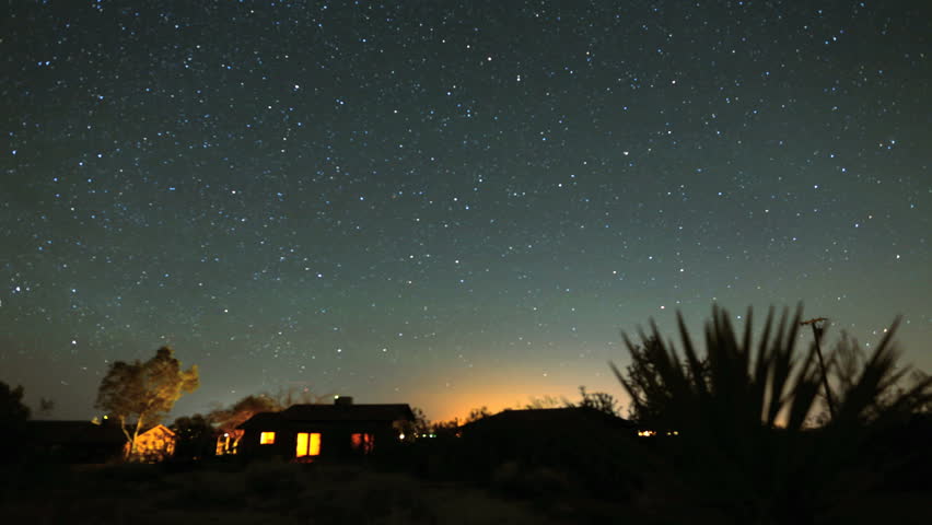4K Star Trails Night Sky Cosmos Galaxy Time-lapse over Cabin. Sunrise from night to day in amazing high resolution at Joshua Tree National Park, California. 