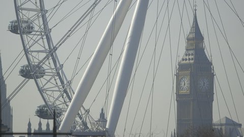 LONDON, UK - CIRCA MARCH 2014: Time Lapse of Big Ben (Elizabeth Tower, Clock Tower) through the spokes of the London Eye. Tourists can be seen in passenger capsules enjoying the views of the capital